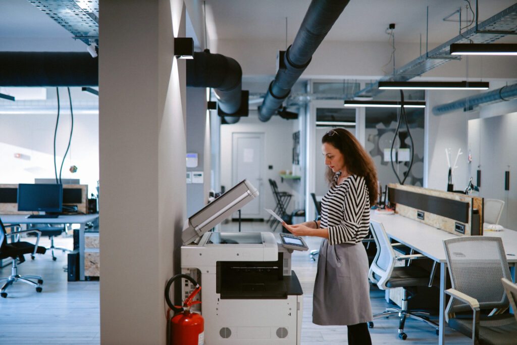 Woman Using The Photocopier Machine At The Office